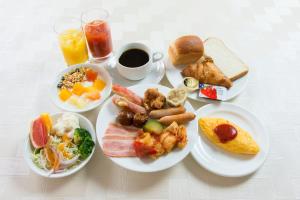 een tafel met borden met ontbijtproducten en -dranken bij Grand Park Hotel Panex Iwaki in Iwaki
