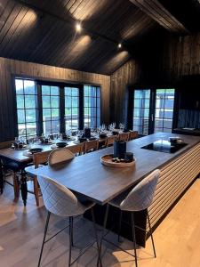 une grande salle à manger avec des tables et des chaises en bois dans l'établissement Ny kvalitetshytte-158 m2-Kikut!, à Flatåker