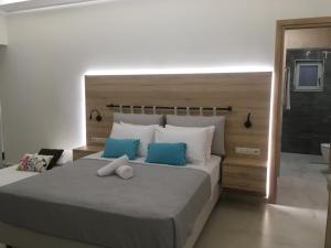1 dormitorio con 1 cama grande con almohadas azules y blancas en ΤΟ ΠΕΤΡΙΝΟ / THE PETRINO APARTMENTS, en Stoupa