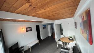Oakura的住宿－Butlers Reef Accommodation，客房设有桌椅和木制天花板。
