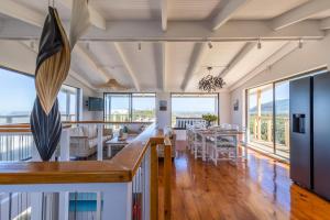 Abalone Beach House في كوربومستراند: غرفة طعام وغرفة معيشة مع طاولة وكراسي