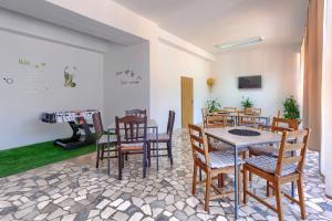 a dining room with a table and chairs and a piano at Hostel Monte Zaro in Pula