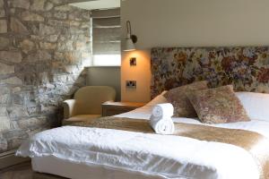 um quarto com uma cama grande e uma parede de pedra em Square & Compass em Two Dales