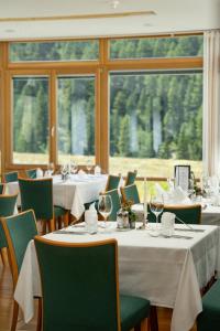 ein Restaurant mit weißen Tischen und Stühlen und einem großen Fenster in der Unterkunft Hotel Cevedale in Sulden