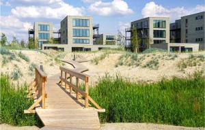 a wooden boardwalk in the sand in front of buildings at Lovely Home In Lembruch-dmmer See With Sauna in Lembruch