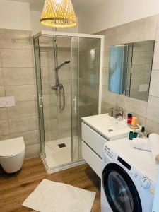 a bathroom with a shower and a washing machine at Cala Rossa by Saraï, Apt T2 4 personnes, dans Résidence hôtelière avec piscine in Lecci