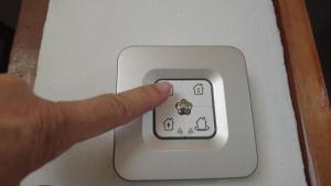 une personne appuyant sur un bouton sur un interrupteur lumineux dans l'établissement Haus Anderes, à Casas Las Basas