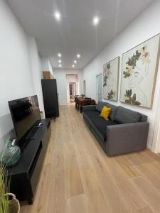a living room with a couch and a flat screen tv at UIM Mediterraneo CASA Virgen de los Dolores Wifi in Puerto de Sagunto +11 photos