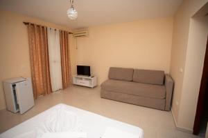 sala de estar con sofá y TV en Hotel Sunrise, en Golem
