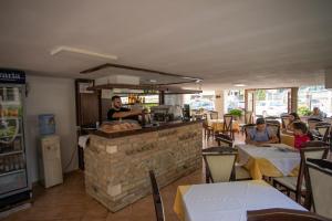 a restaurant with a counter with people sitting at tables at Hotel Sunrise in Golem