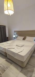 a large bed in a bedroom with a light at Odysseas apartments in Agathonisi