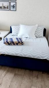 uma cama com lençóis e almofadas azuis e brancos em 2кк люкс 3-я Слободская/Кузнецкая em Mykolaiv