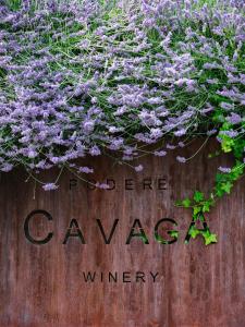 un cartello con fiori viola su una recinzione di legno di Agriturismo Podere Cavaga Lago d'Iseo Agribio Winery a Foresto Sparso
