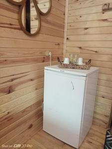 MJORA Bungalov Ayder في Güroluk: خزانة بيضاء صغيرة في غرفة مع جدران خشبية