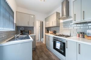 een keuken met witte kasten en een fornuis met oven bij 3 bedroom Shalom Sleeps 5 - Ideally Located in Hull in Hull