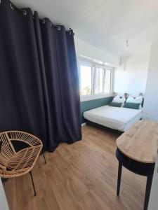 ein Schlafzimmer mit einem Bett, einem Tisch und einem schwarzen Vorhang in der Unterkunft Superbe appartement in Pau