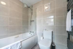 a bathroom with a tub and a toilet and a sink at 3 bedroom Shalom Sleeps 5 - Ideally Located in Hull- 2 Mins walk to Vibrant Newland Ave in Hull +19 photos
