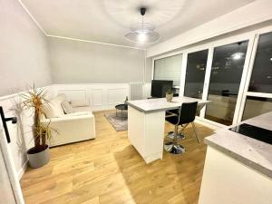 ein Wohnzimmer mit einem weißen Schreibtisch und einem Sofa in der Unterkunft Superbe appartement in Pau