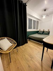 ein Schlafzimmer mit einem Bett, einem Stuhl und einem Tisch in der Unterkunft Superbe appartement in Pau