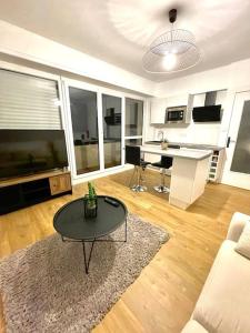 ein Wohnzimmer mit einem Sofa und einem Tisch in der Unterkunft Superbe appartement in Pau