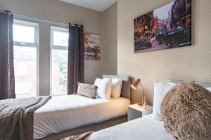 een slaapkamer met 2 bedden en een raam bij 3 bedroom Shalom Sleeps 5 - Ideally Located in Hull in Hull