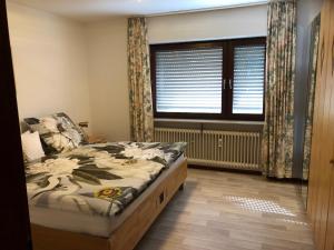 Un dormitorio con una cama y una ventana grande. en GERBER Ferienwohnung, en Bretzenheim