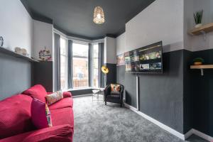 een woonkamer met een roze bank en een stoel bij 3 bedroom Shalom Sleeps 5 - Ideally Located in Hull in Hull