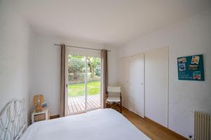 アルカションにあるVilla de 4 chambres a Arcachon a 650 m de la plage avec jardin et wifiのベッドルーム1室(ベッド1台、大きな窓付)