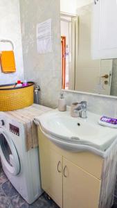 a bathroom with a sink and a washing machine at Milenka Apartment in Split