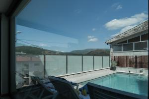 balcón con piscina y vistas al agua en Refúgio da Cabreira, en Vieira do Minho
