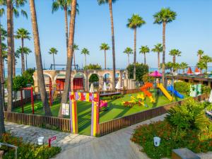 a playground at a resort with palm trees at Meryan Hotel - Ultra All Inclusive in Okurcalar
