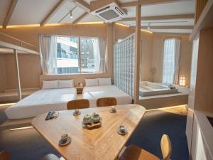 a bedroom with a bed and a table and a tub at UH Suite Seoul Square in Seoul +35 photos