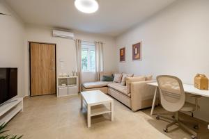 salon z kanapą i stołem w obiekcie Renovated 1st-floor apt-close to the park w Atenach