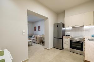 cocina con electrodomésticos de acero inoxidable y sala de estar. en Renovated 1st-floor apt-close to the park en Athens