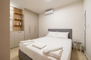 1 dormitorio con 1 cama grande con sábanas blancas en Renovated 1st-floor apt-close to the park en Athens