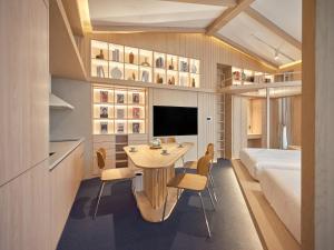 a room with a bed and a table and chairs at UH Suite Seoul Square in Seoul