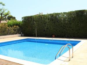 a large blue swimming pool next to a hedge at Homing Golf Bonmont 12 in Bonmont Terres Noves
