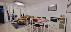 a kitchen and living room with a table and chairs at TRP16 - Cozy 2BR Townhouse near Clark Airport, Aquaplanet & Dino Island in Angeles