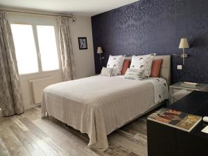 - une chambre avec un grand lit et une fenêtre dans l'établissement Les Suites Champenoises, à Reims