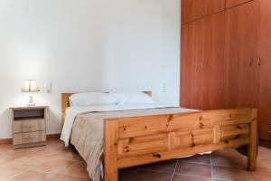 a bedroom with a bed and a wooden cabinet at Artemis Villas 
