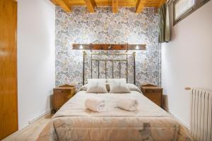 a bedroom with a large bed with two pillows on it at Casa Batlle Boix in Les Iglésies