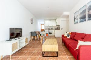 ロルモンにあるJoli appartement avec jardin / Vieux-Lormontの赤いソファとテーブルのあるリビングルーム
