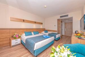 オクルカラールにあるMeryan Hotel - Ultra All Inclusiveのベッド2台とソファが備わるホテルルームです。