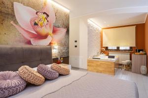 1 dormitorio con 1 cama con una pintura floral en la pared en B&B Golden House & spa, en Rose