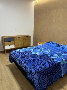 sypialnia z niebieskim łóżkiem i komodą w obiekcie Villa Regina w mieście Pato Branco