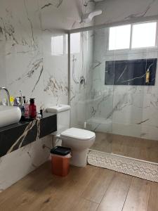een badkamer met een toilet, een douche en een wastafel bij Villa Regina in Pato Branco