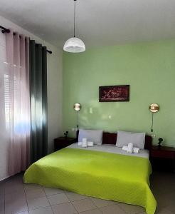 een groene slaapkamer met een groot groen bed met verlichting bij Bella Vista in Balíon