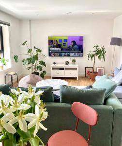 a living room with a green couch and a tv at Large 2bed flat near TowerBridge in London