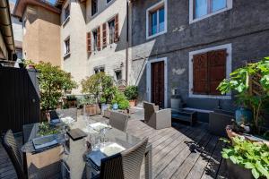 a patio with a table and chairs and a building at La Terrasse du vieil Annecy in Annecy