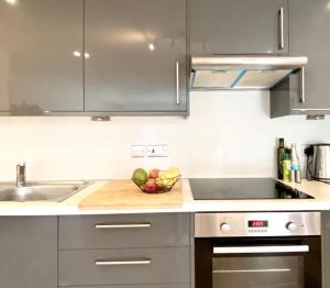 a kitchen with a bowl of fruit on a cutting board at Large 2bed flat near TowerBridge in London